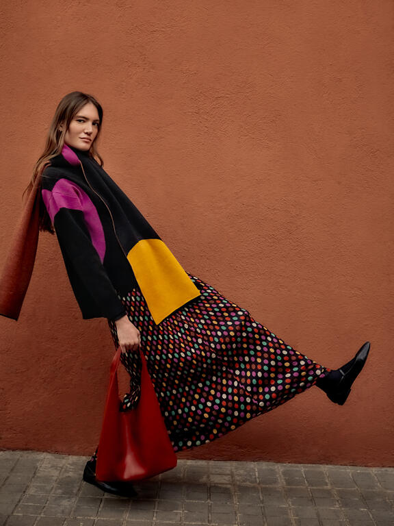 Modella con borsa e gonna a fantasia 